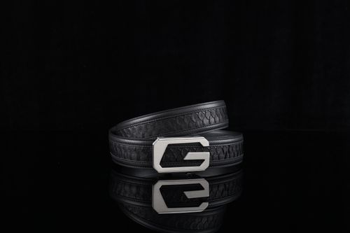 Free A stylish black leather belt with a distinctive silver buckle on a reflective black surface. Stock Photo