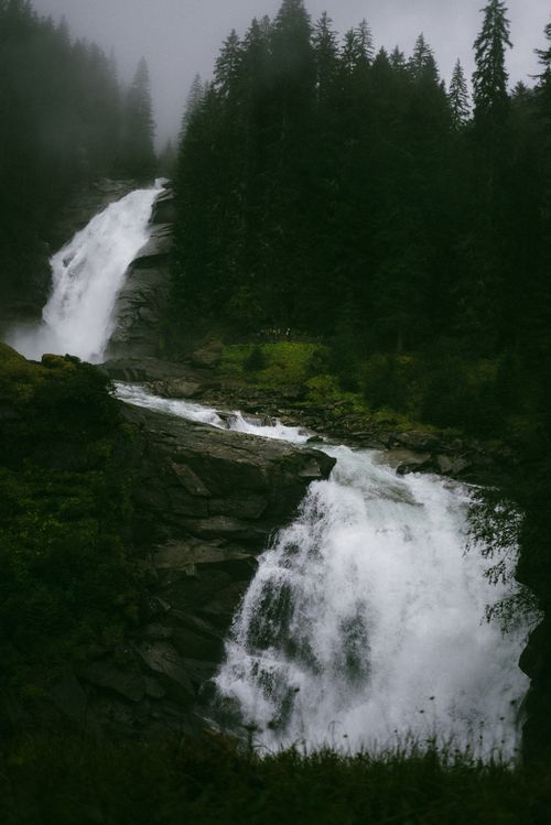 Free Dramatic view of twin waterfalls cascading through a dense forest in misty weather. Stock Photo