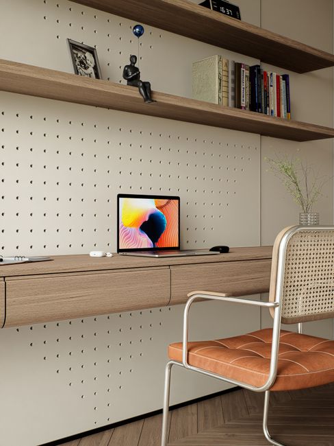 Contemporary home office with elegant decor featuring a laptop and minimalistic wooden shelves.