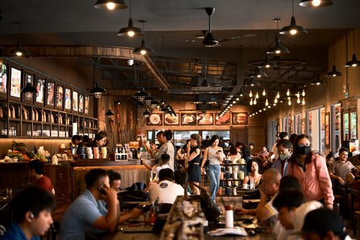Cozy coffee shop filled with people enjoying their drinks and conversation.