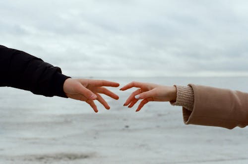 Hand Together with Sea in Background