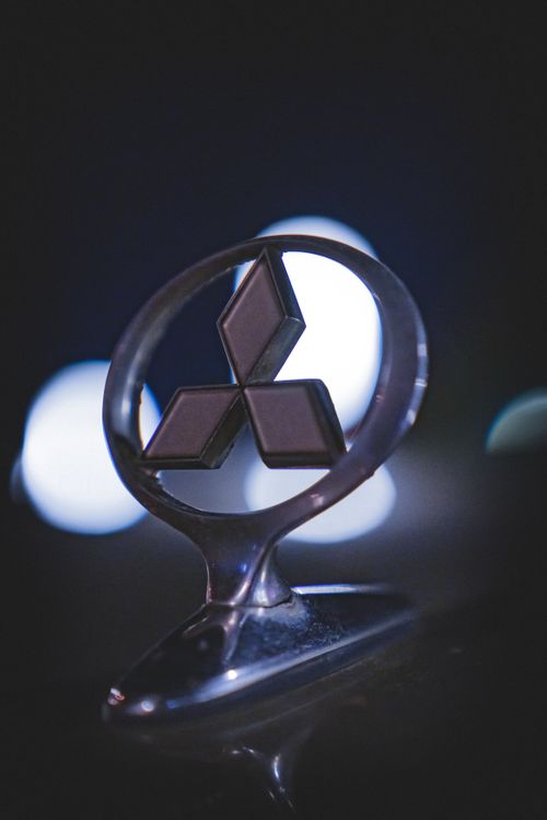 Free Night shot of a car emblem highlights its metallic design with blurred city lights in Baku. Stock Photo