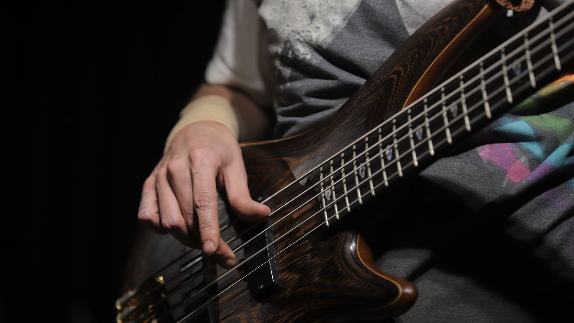 Modafinil for Musicians on Tour: Maximising Energy and Focus A musician's hands playing bass guitar during an indoor studio music session under stage lighting — modafinil for musicians on tour