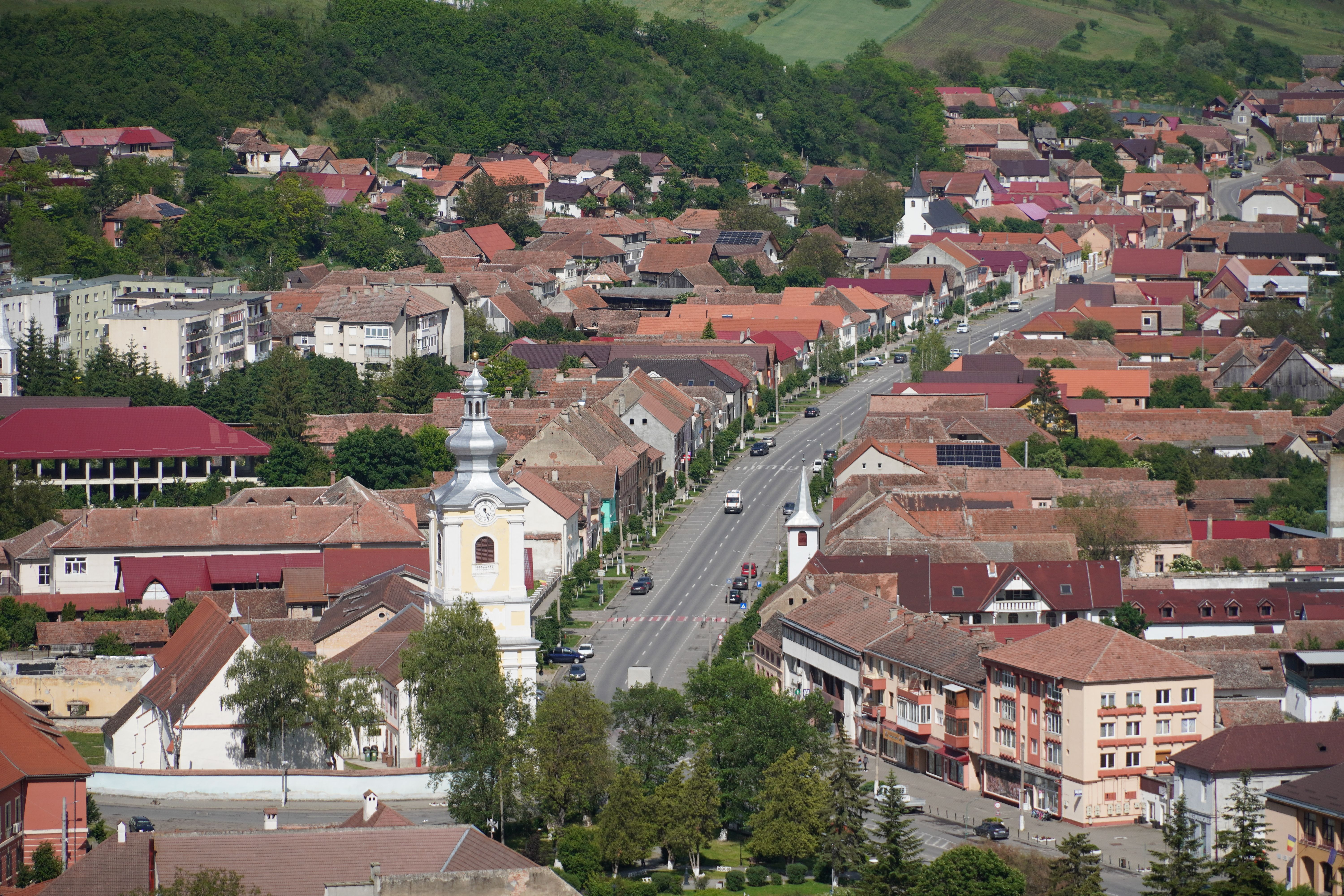 Aerial view of Rupea town in Transylvania, Romania, showcasing traditional architecture and scenic landscapes.