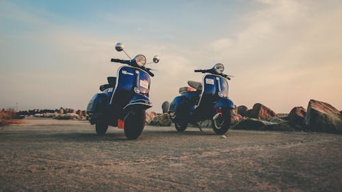 Blue mopeds parked on empty road in countryside