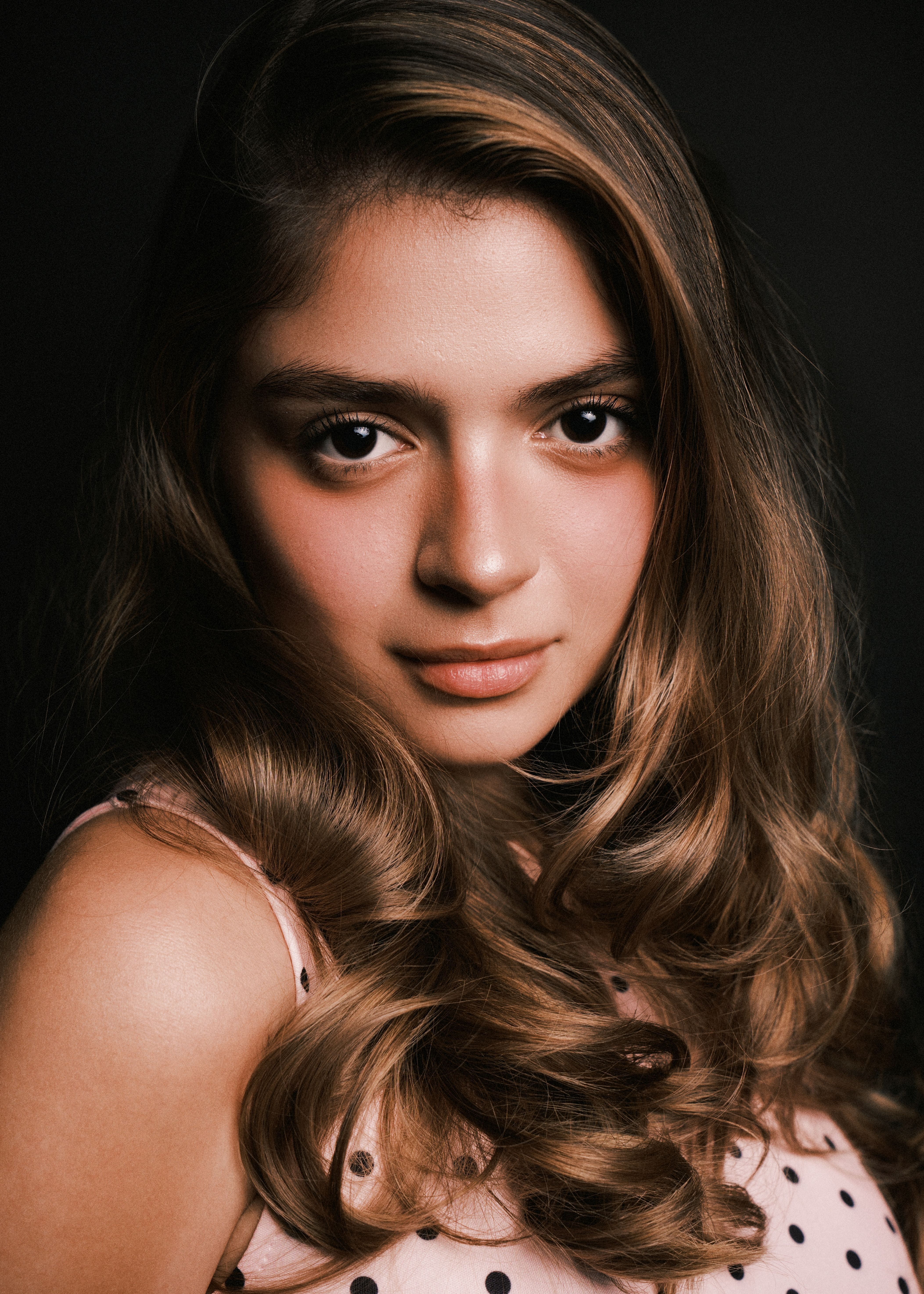 Close-up portrait of a woman with long wavy hair and soft expression.