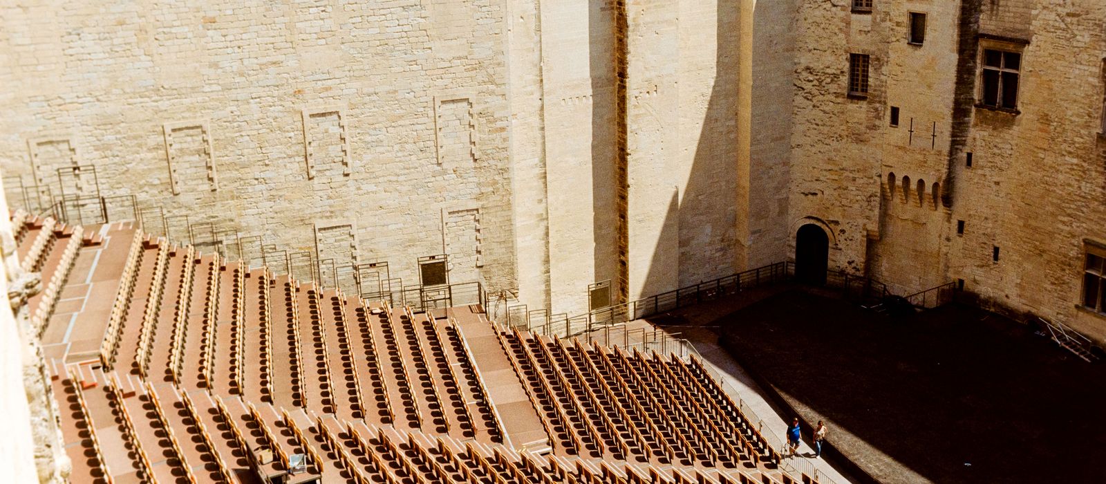 Outdoor view of an empty amphitheater seating area inside the historic Palais des Papes in Avignon, France.
