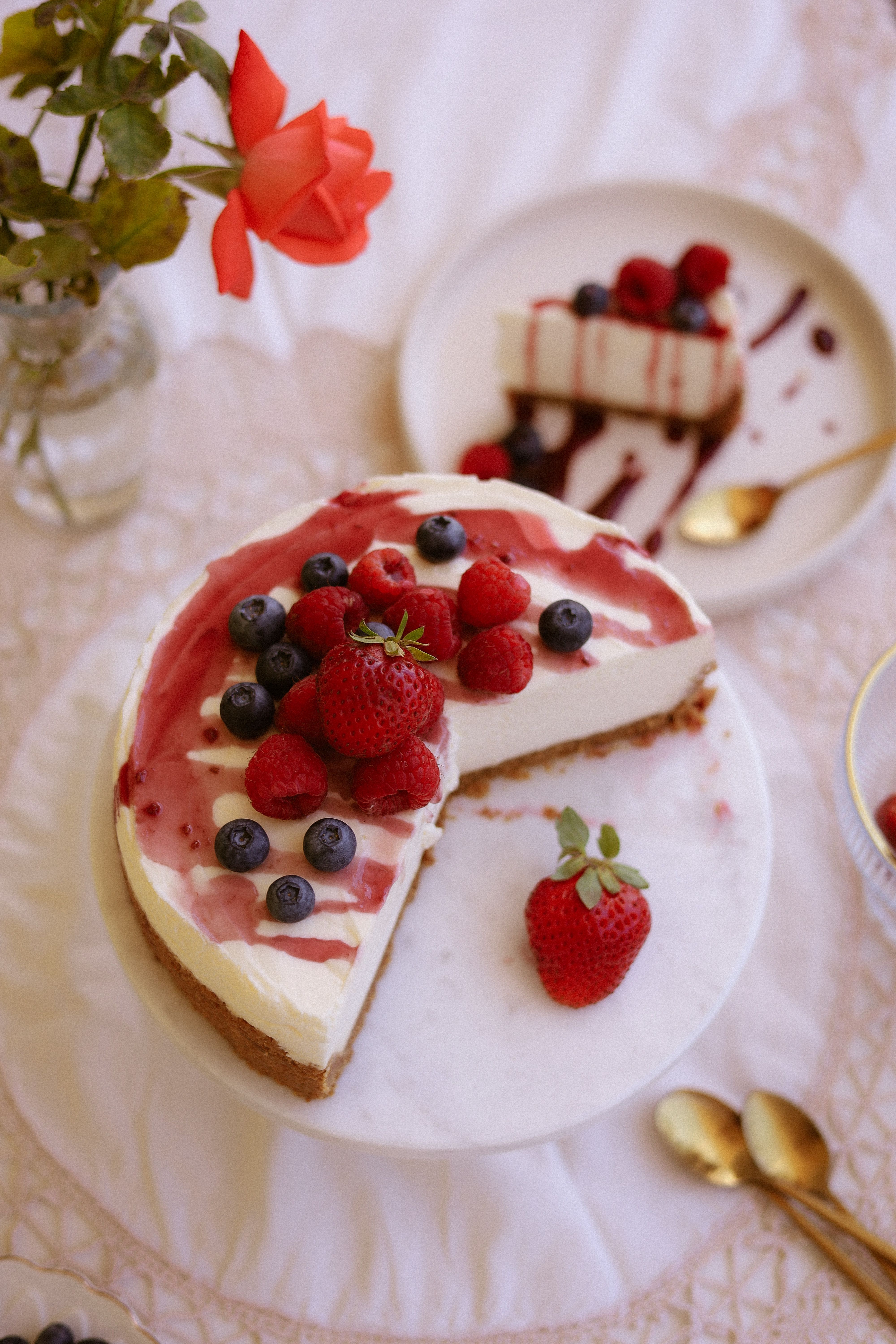 A delectable berry-topped cheesecake on a marble stand, perfect for elegant gatherings.