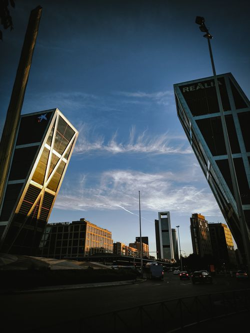 Free Captivating sunset view of Madrid's modern skyline featuring the iconic Puerta de Europa towers. Stock Photo