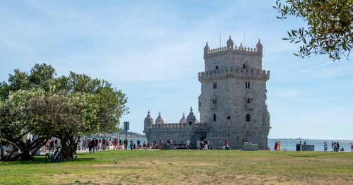 Free A sunny afternoon at the iconic Belém Tower in Lisbon, Portugal with tourists and lush greenery. Stock Photo