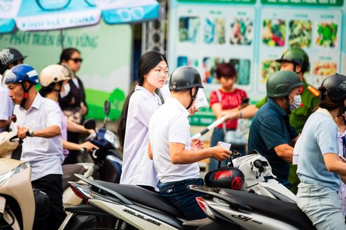 Free Lively street scene in Haiphong, Vietnam with people on scooters and bustling activity. Stock Photo