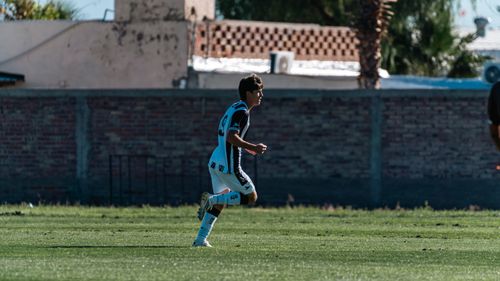 Free Young soccer player running on a grassy field during a daylight game. Stock Photo
