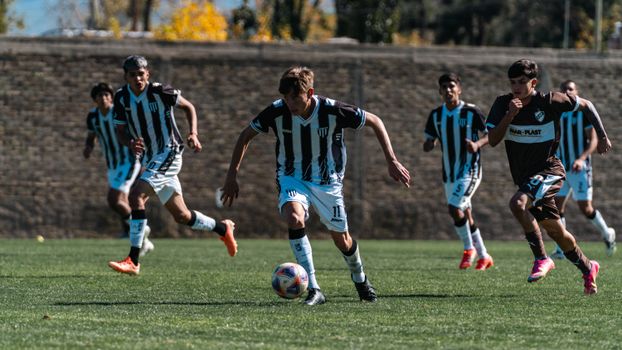 Dynamic scene of a youth soccer match with players in motion on a sunny day.