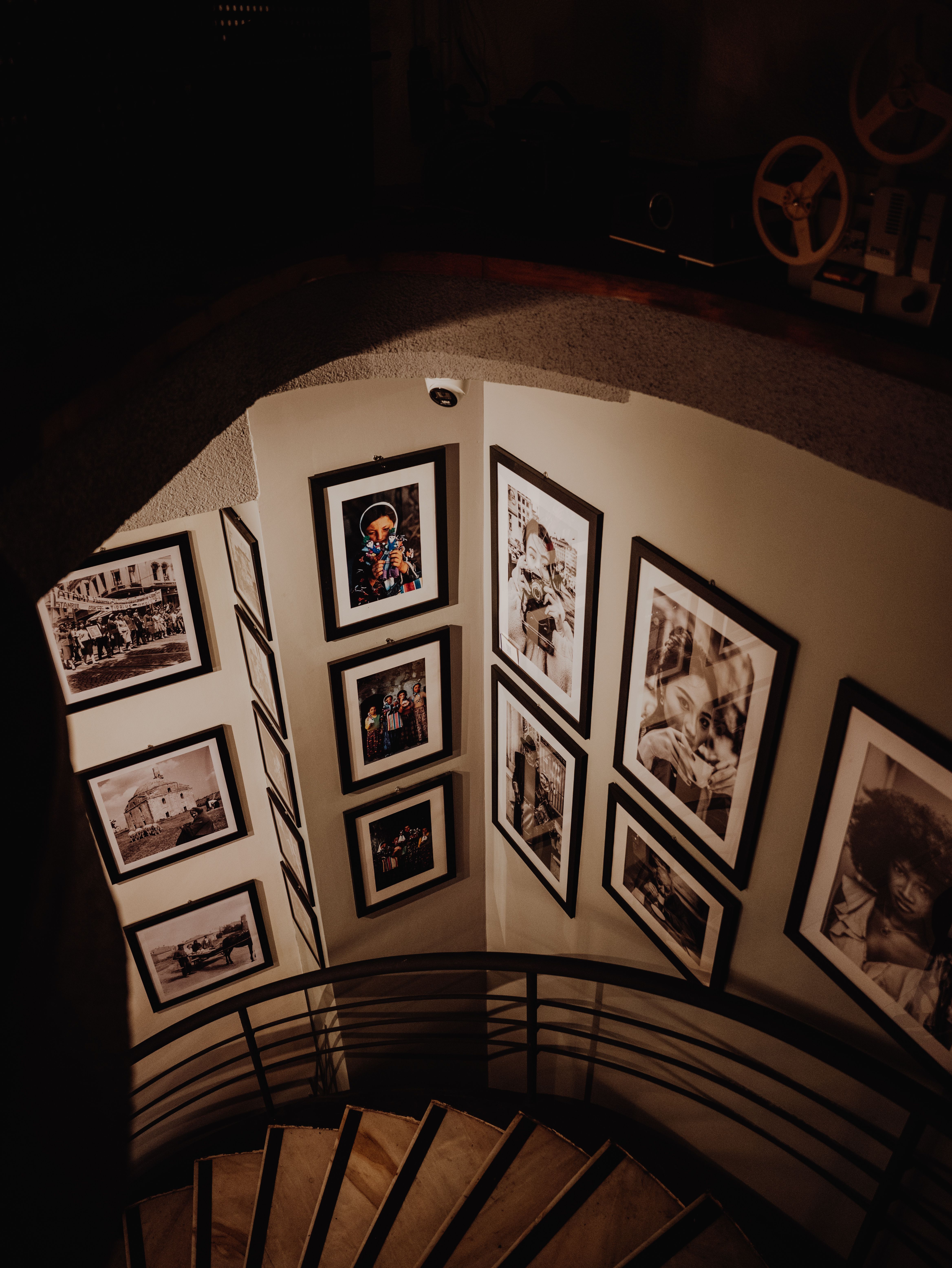 Spiral staircase with framed black and white photos in a dimly lit gallery in Istanbul.