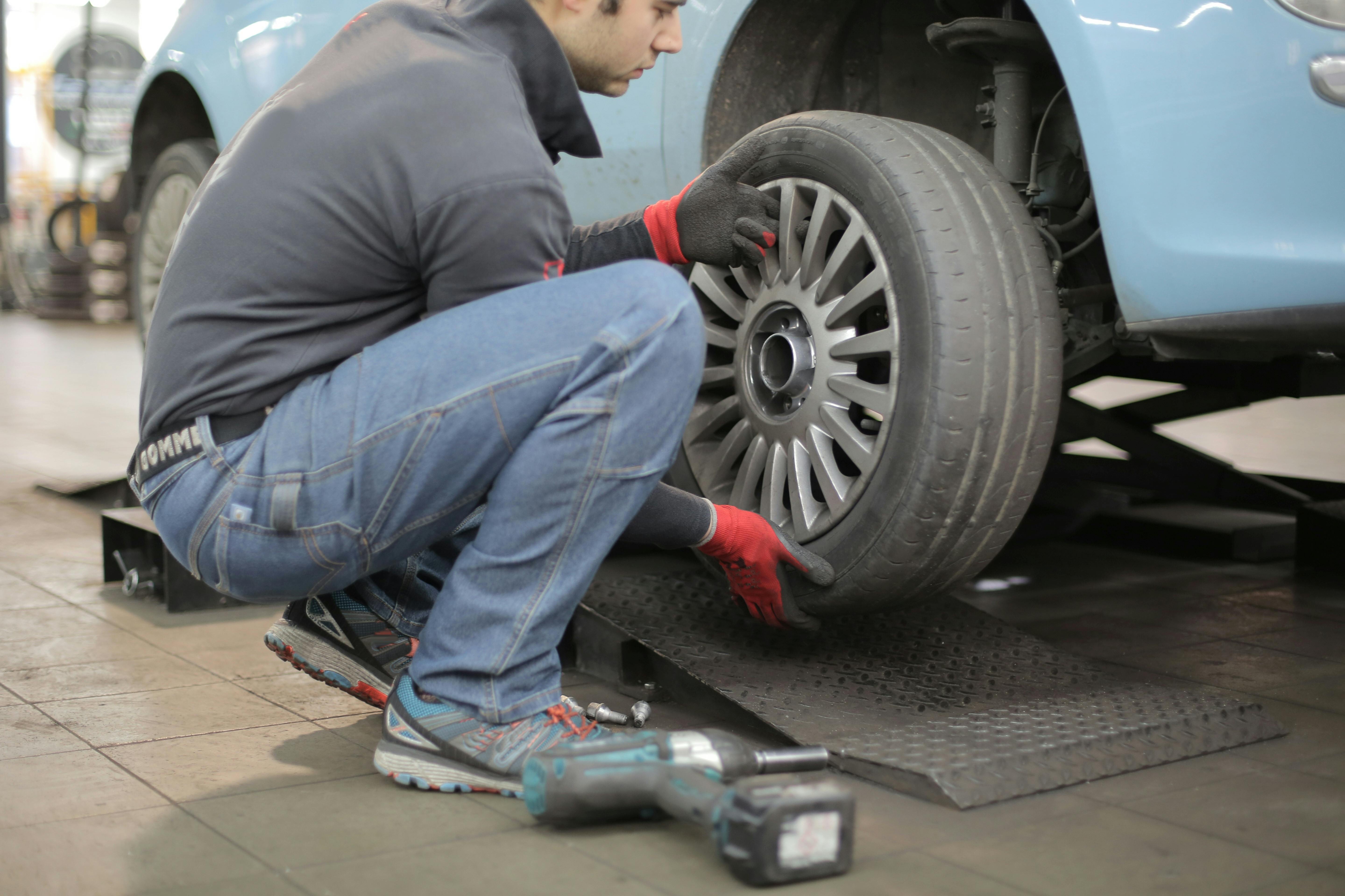 A mechanic replacing car tires