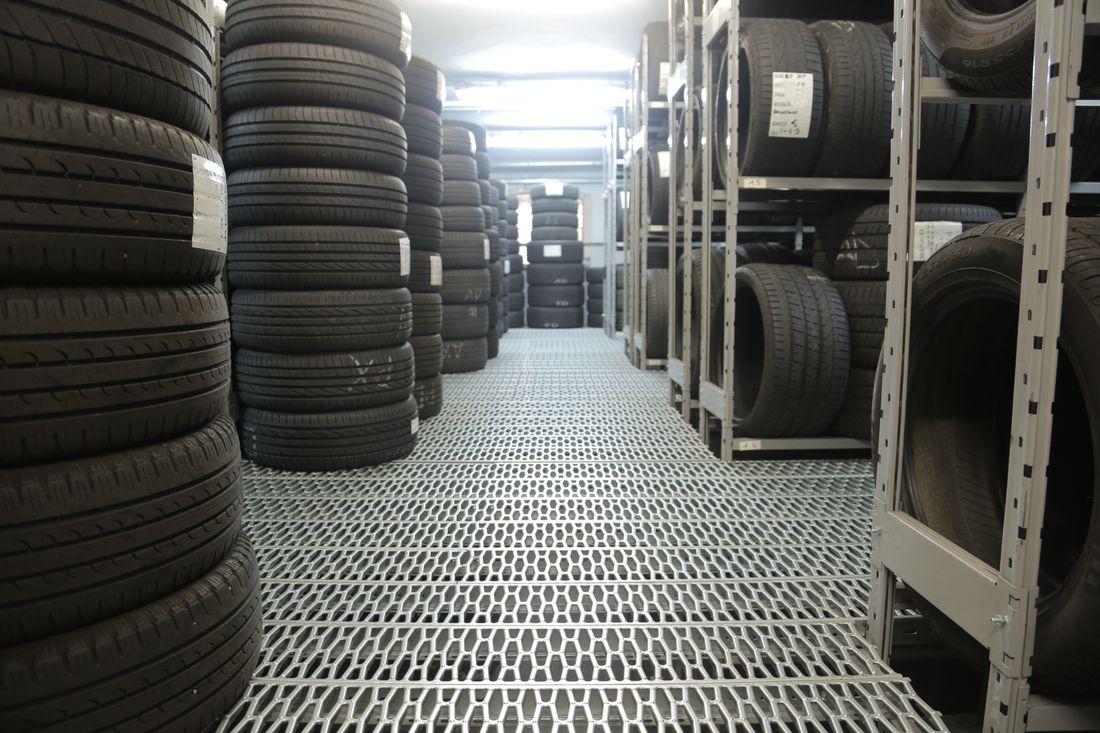 Racks and stacks of tires sorted by size in a tire shop