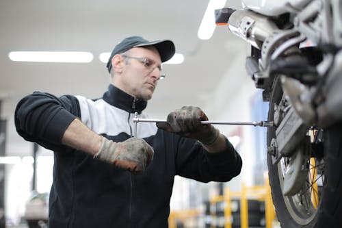 Free Photo of Man Fixing a Motorcycle Stock Photo