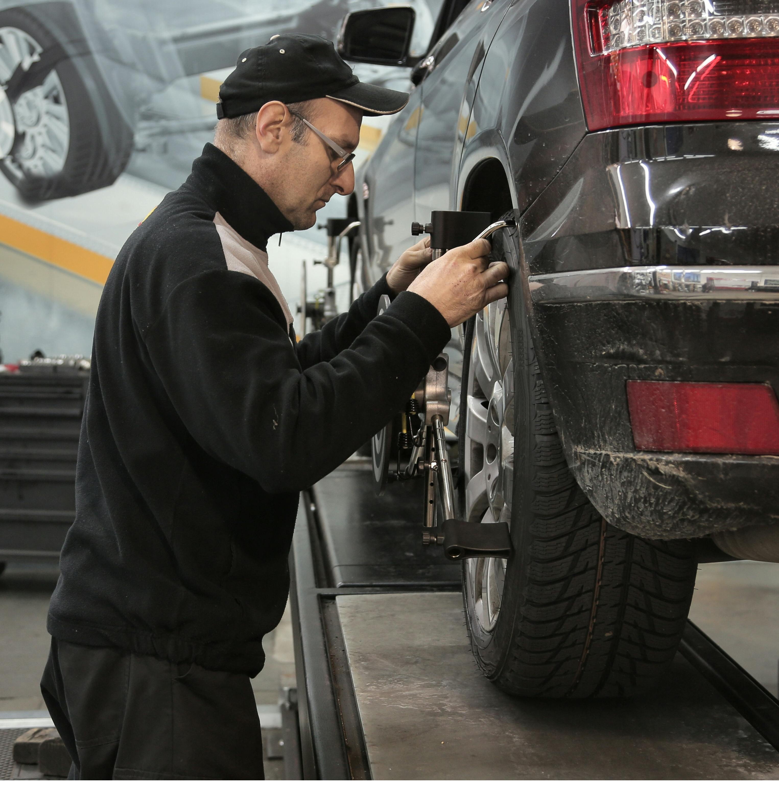 man in black jacket standing beside black car