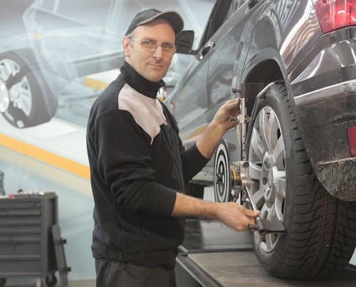 Man in Black Jacket Standing Beside Black Car