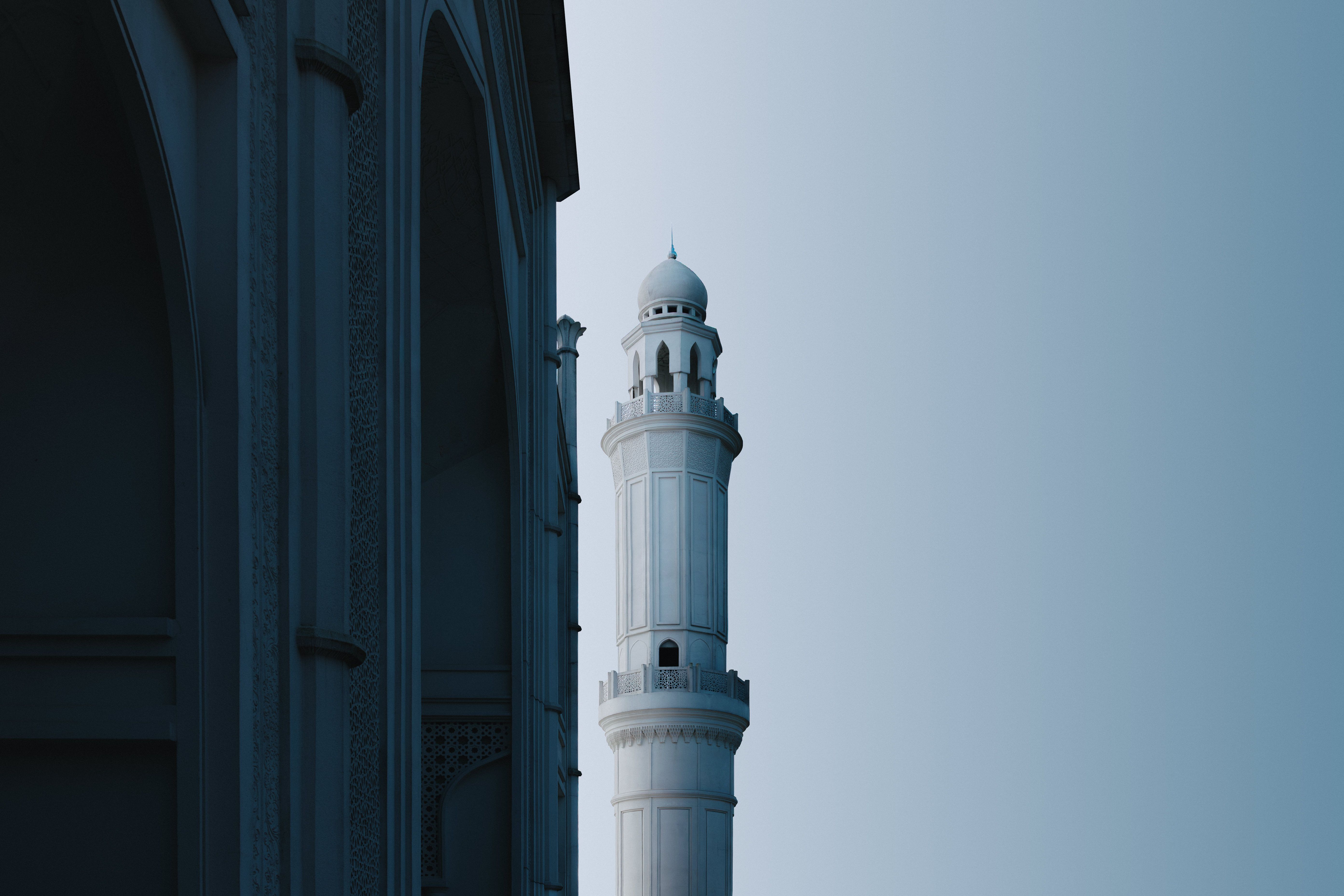 Captivating view of a mosque's minaret in Indonesia during the serene blue hour, showcasing Islamic architecture.