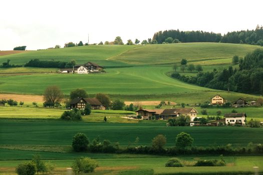 Picturesque landscape showcasing rolling hills and traditional rural homes.