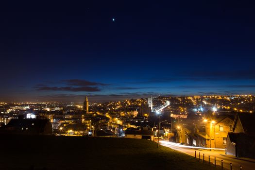 Stunning view of Cork, Ireland at twilight, showcasing city lights and a starry sky.