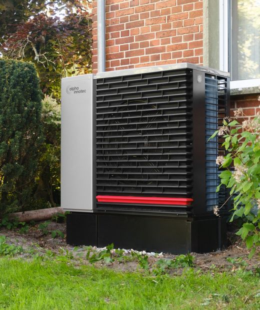 Heat pump outdoor unit beside a house