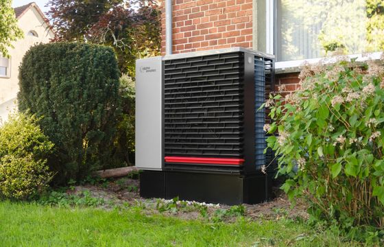Heat pump outdoor unit beside a house