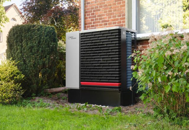 Heat pump outdoor unit beside a house