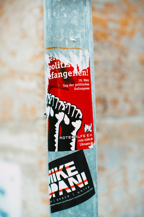 Free Shabby gray metal pillar on street with various stickers against blurred brick wall Stock Photo
