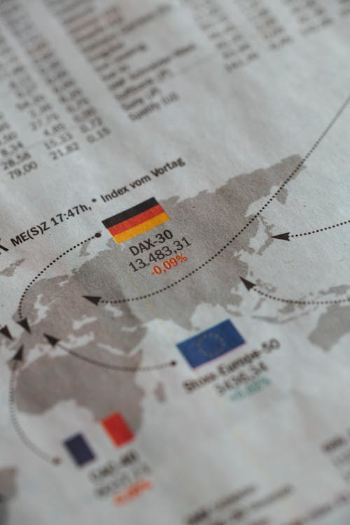 From above of business newspaper with trading indexes and flags of Germany France and European Union