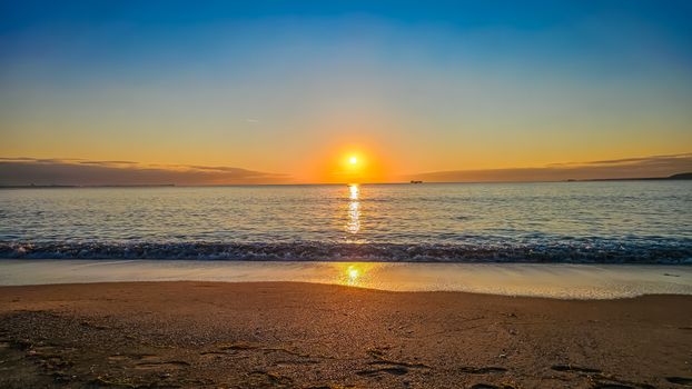 Beautiful sunset over the Black Sea with golden reflections on the water at Burgas Beach.