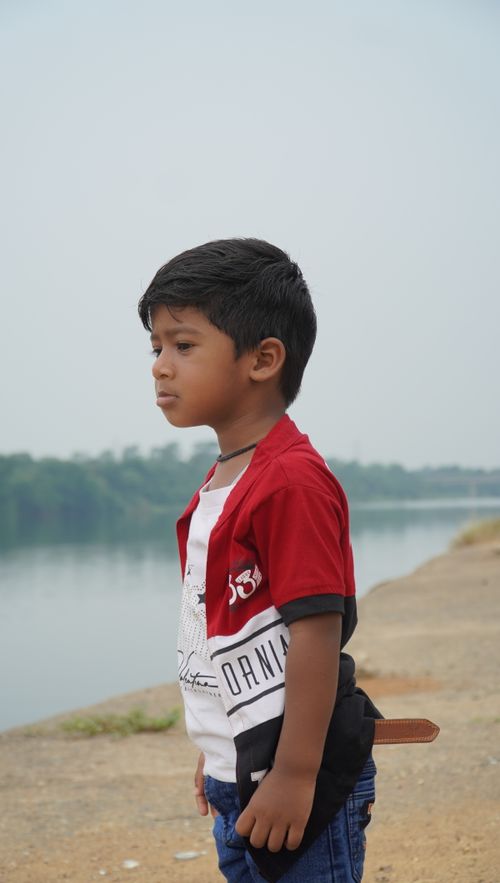 Free A child stands by a river in Jamshedpur, Jharkhand, India, looking contemplative. Stock Photo