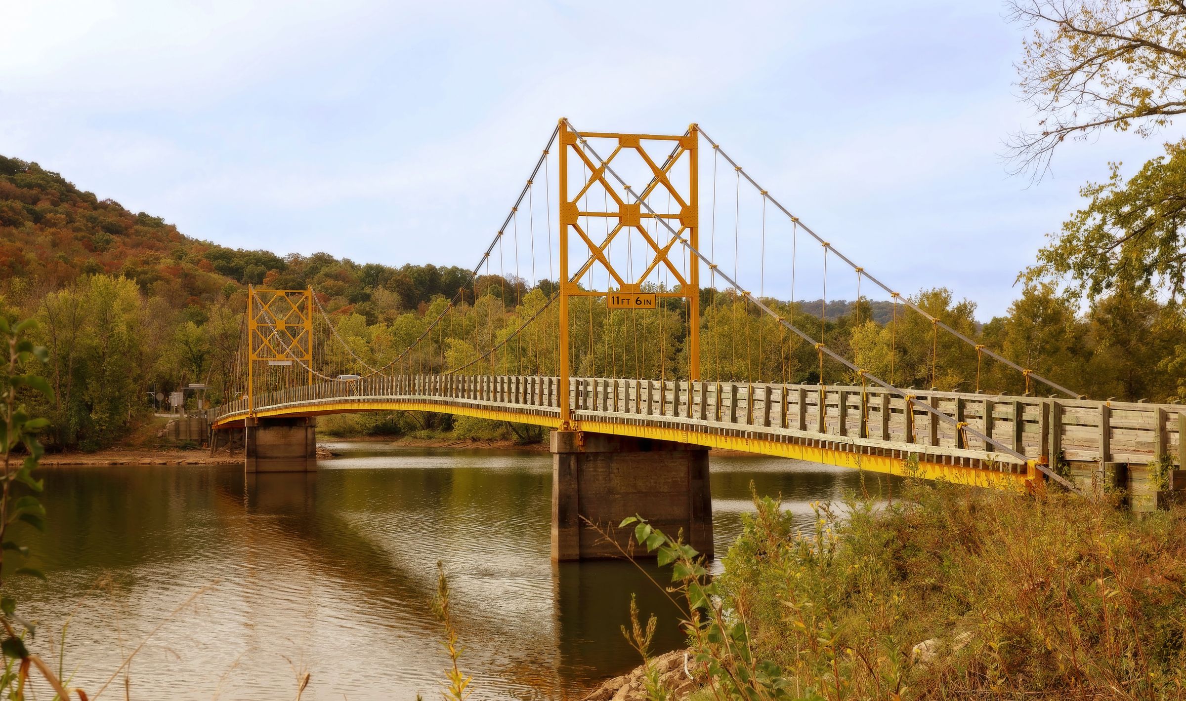 The historic Beaver Bridge over calm water in autumn near Eureka Springs, Arkansas