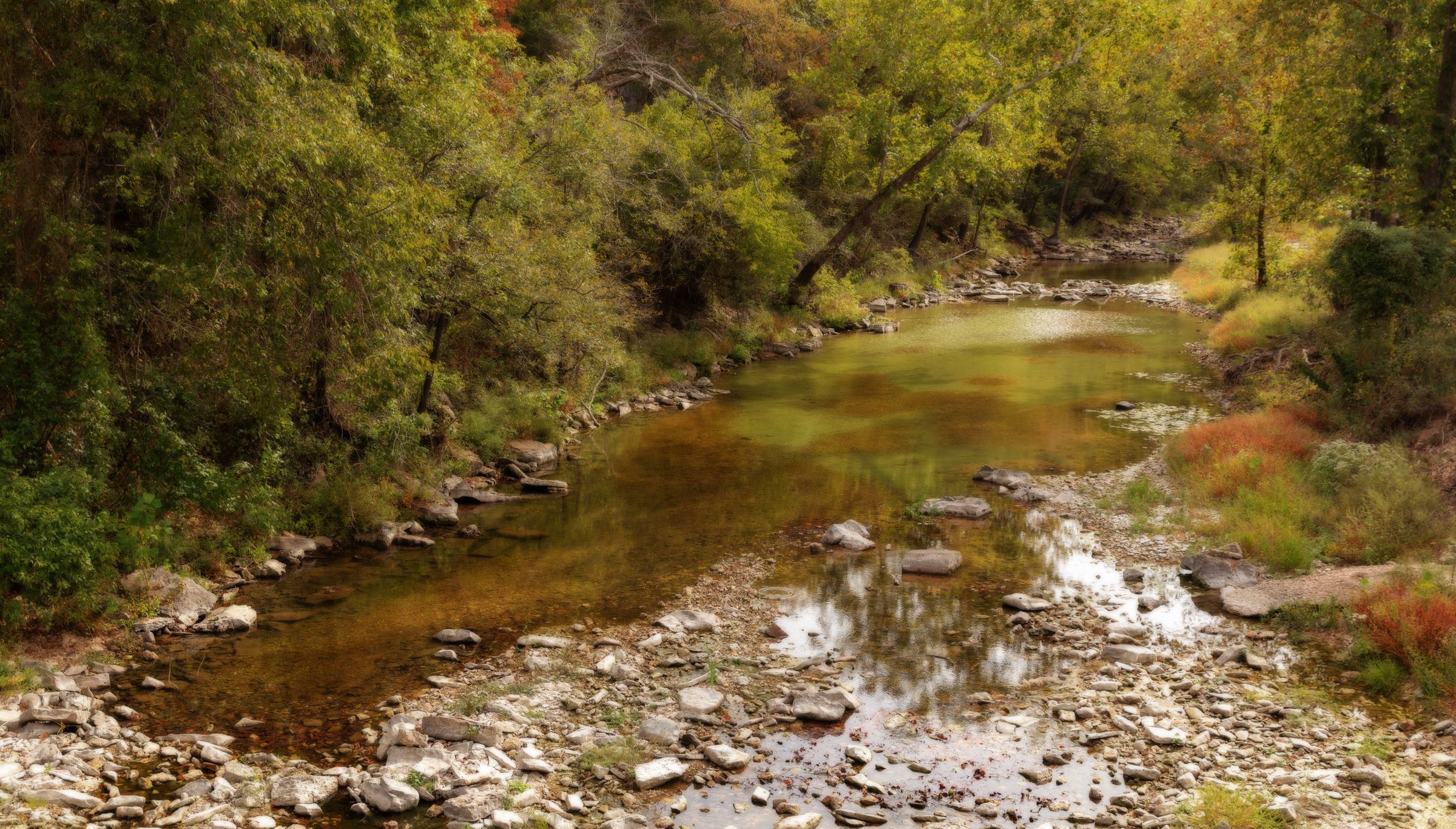 A clear river winding through autumn forest in the Arkansas Ozarks