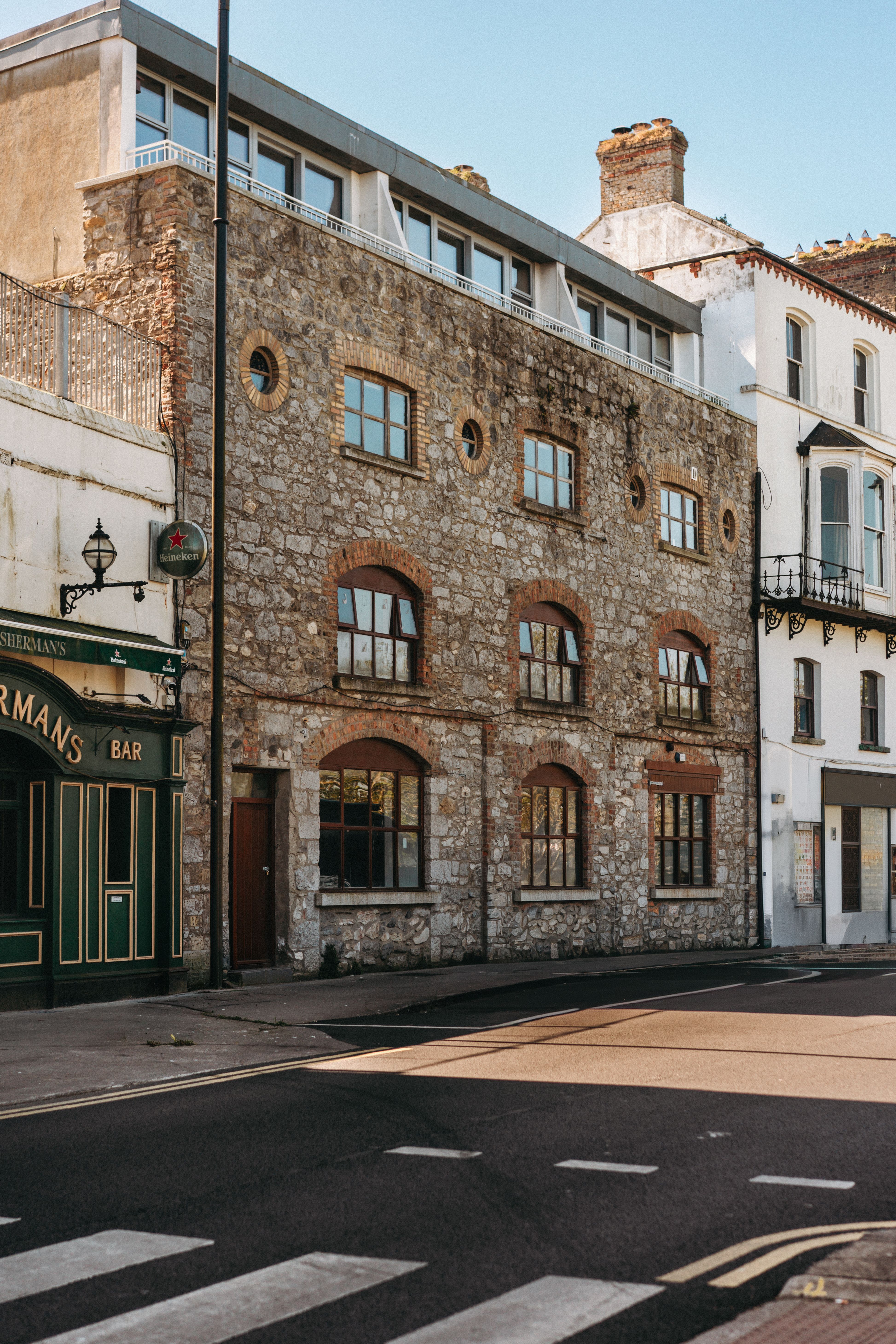 Charming stone facade of a historic building on a sunny Dublin street.