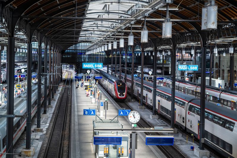 A vibrant view of Basel SBB train station with multiple trains and platforms in Switzerland.