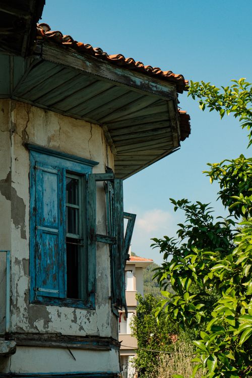 Free A vintage Mediterranean home with blue shutters and rustic charm. Stock Photo
