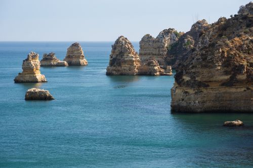 Free Dramatic Algarve coastline with stunning rock formations in clear blue waters. Stock Photo