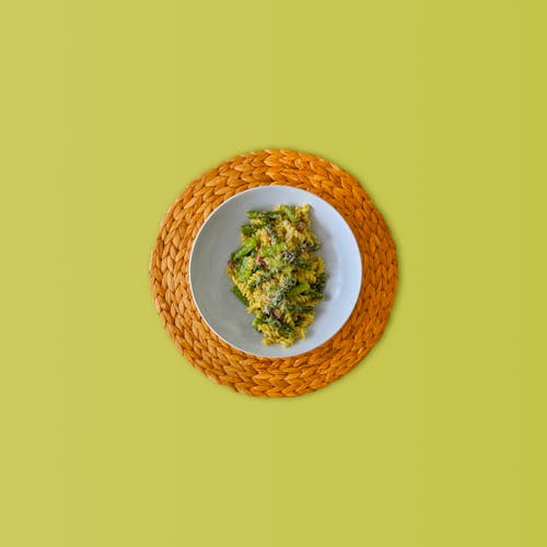 緑の野菜料理と茶色の丸皿