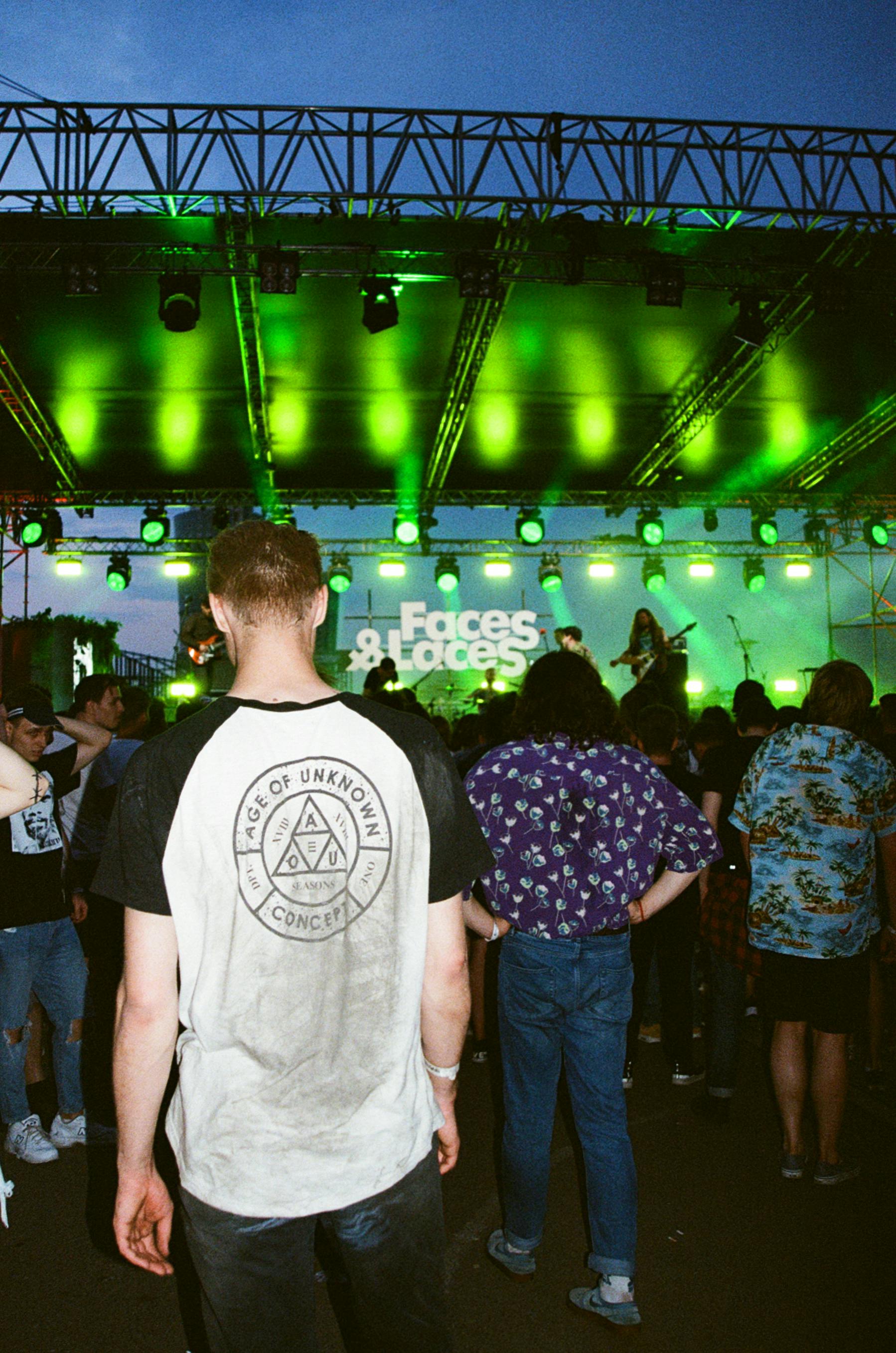 Energetic crowd enjoying a live rock band performance under vibrant stage lights in Moscow.