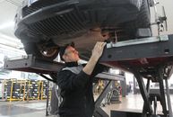 机械师在车库的电梯上检查汽车，重点是进行车辆维修和保养