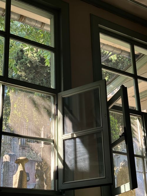 Free Sunlit view of historic garden through open window in İstanbul, Türkiye. Stock Photo