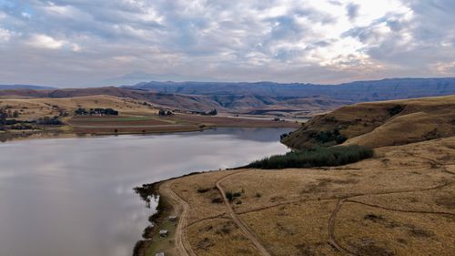 Free Scenic aerial view of lake and rolling hills under cloudy sky in South Africa. Stock Photo