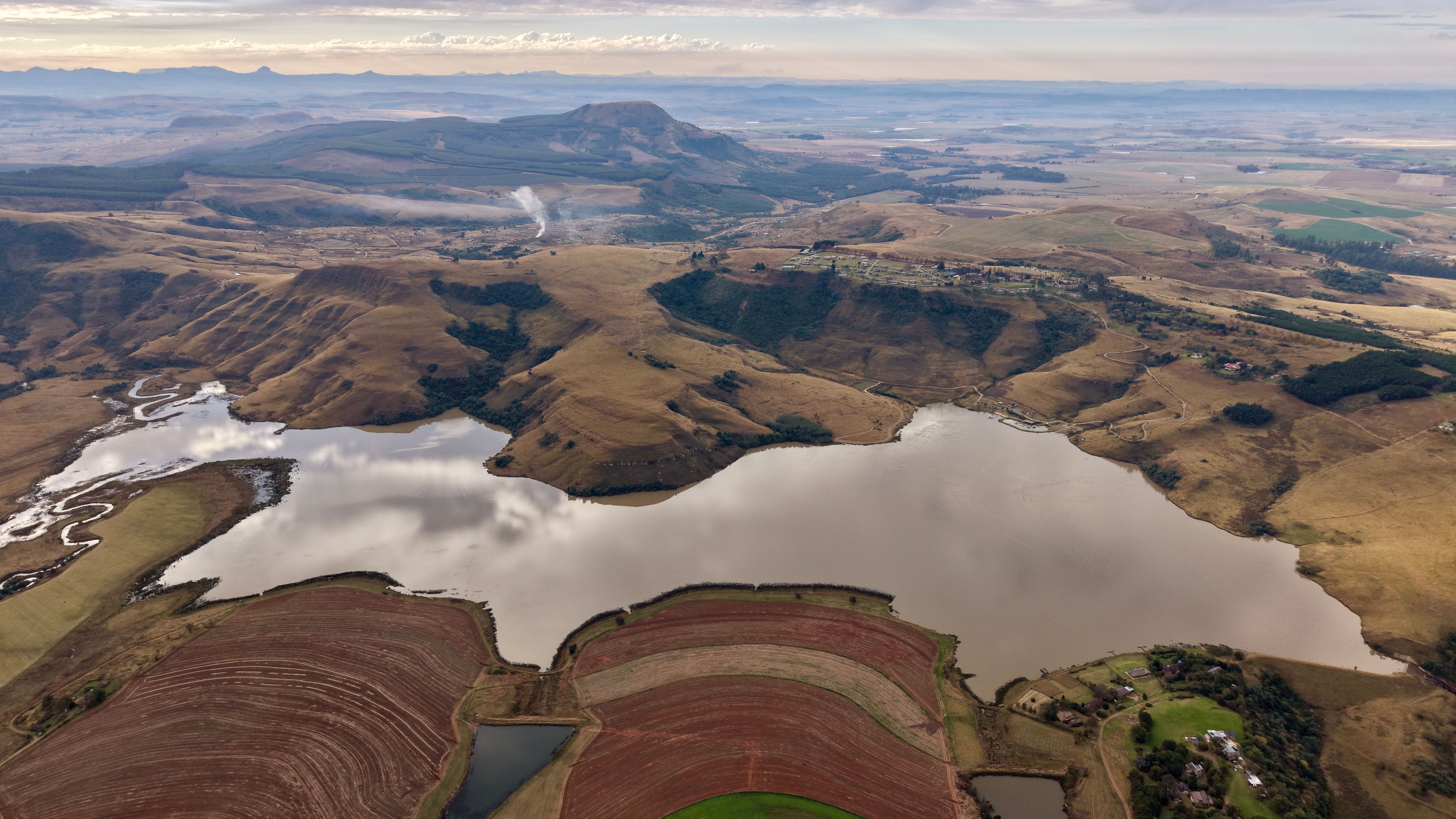 A stunning aerial shot showcasing the diverse terrain and serene lake of South Africa.