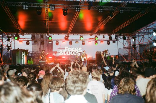 Crowd enjoying a live band performance at Faces & Laces festival in Moscow, vibrant night atmosphere.