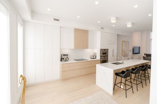 Free Spacious modern kitchen with minimalist design, featuring white cabinets and a center island. Stock Photo