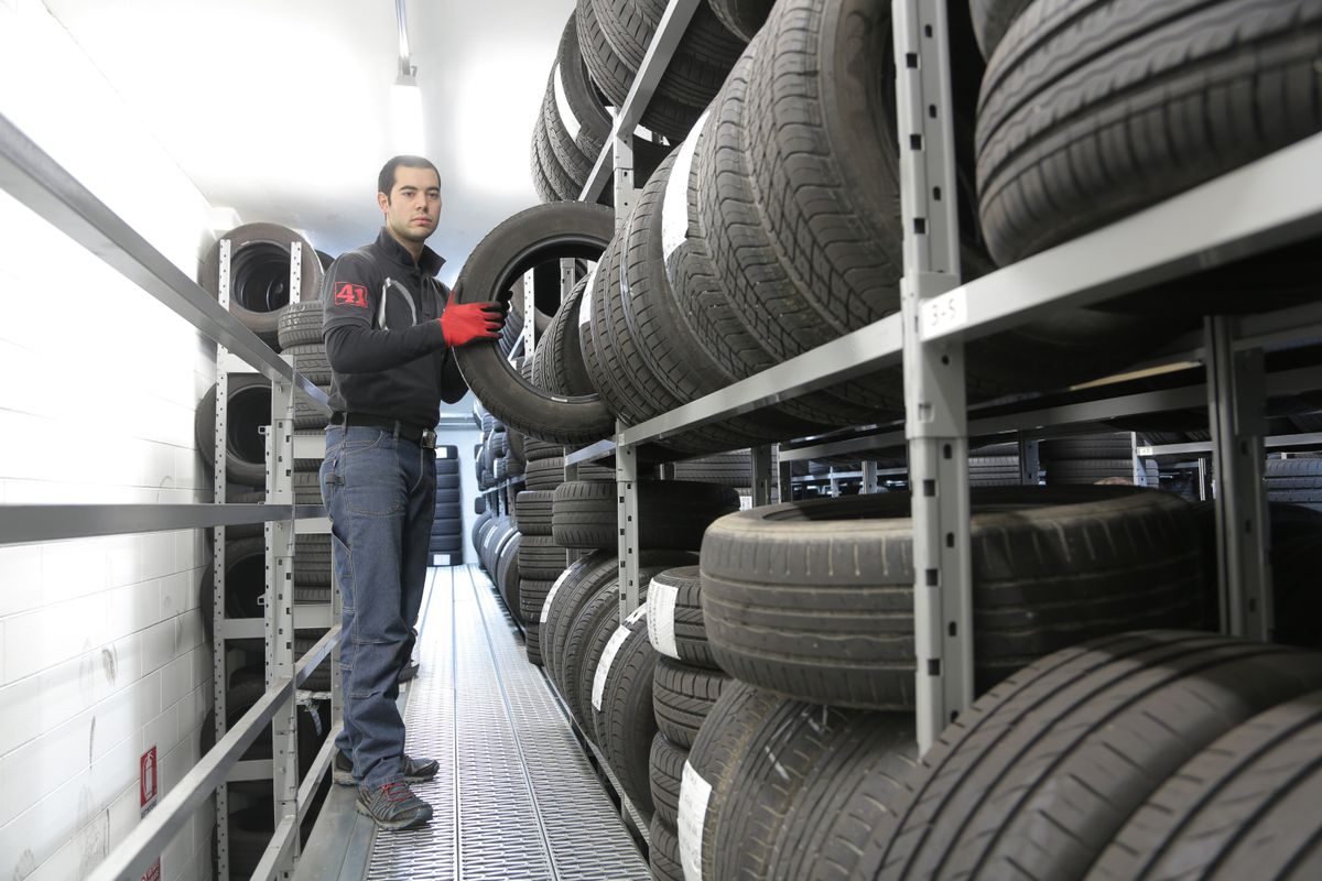 Worker pulling a tire from tall shelves of tires