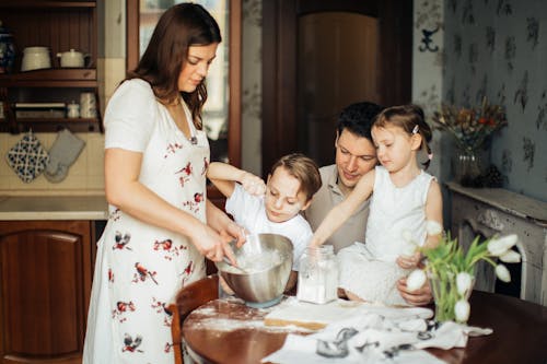 Photo of Woman Baking Near Her Family