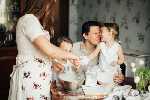 Photo of Woman Baking Near Her Family